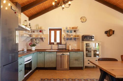 a kitchen with blue cabinets and a wooden table at Casa de Campo La Estancia in Tarifa