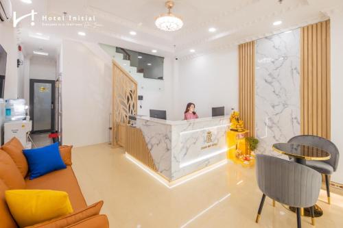 a woman sitting at a counter in a lobby at Hotel Initial-Benthanh in Ho Chi Minh City