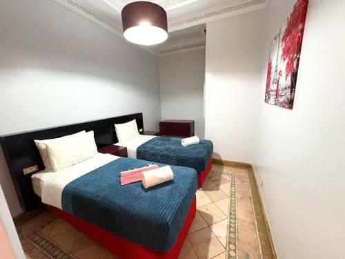 a room with two beds in a room at Appartement standing piscine la palmeraie in Marrakech