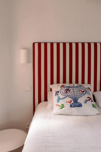 a bed with a red and white striped headboard at Villa PIPA POLARIS I suite BEBOP - vue panoramique & piscine in Spéracèdes