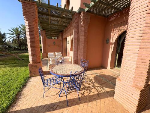 a patio with a table and chairs on a patio at Appartement standing piscine la palmeraie in Marrakech