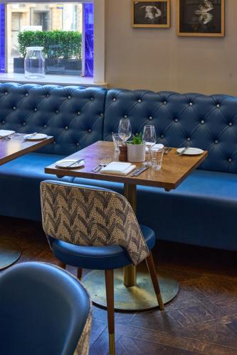 a table in a restaurant with a blue couch at Harbour Hotel & Spa Bristol in Bristol