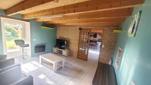a view of a living room with a tv and a table at Kermarc'heg in Guerlesquin