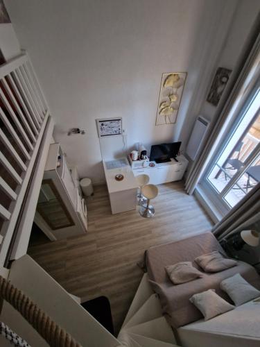 Una pequeña sala de estar con un sofá y una mesa. en Ton petit coin de paradis avec balcon au Trouville Palace, en Trouville-sur-Mer