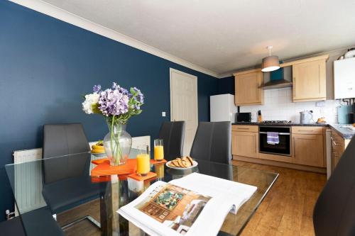 una cocina con una mesa de cristal con un jarrón de flores en Bridges Retreat, Newcastle, en Gateshead