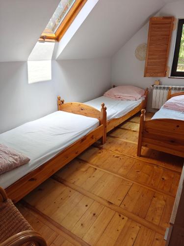 two bunk beds in a room with wooden floors at Dom całoroczny nad jeziorem Sawinda in Woszczele