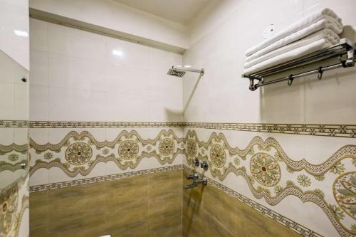 a bathroom with a shower with gold and white tiles at Hotel Lookout Stay in New Delhi