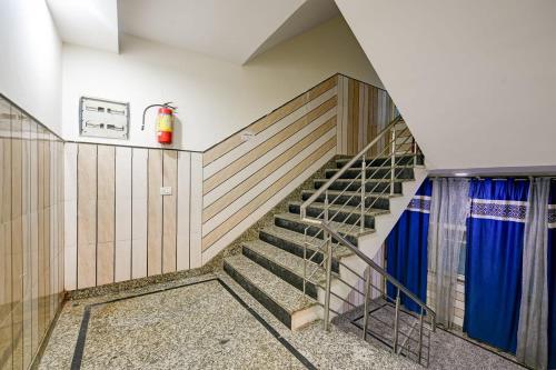 a staircase in a house with a fire extinguisher on the wall at Hotel Lookout Stay in New Delhi