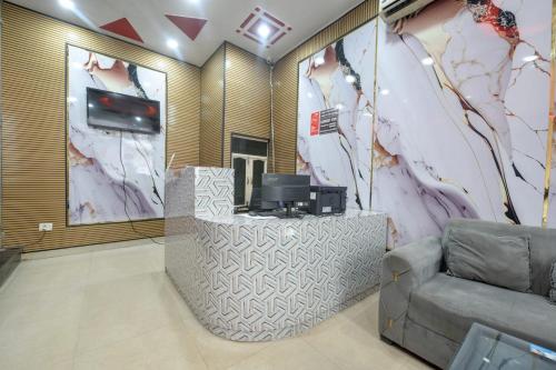 a lobby with a couch and a tv on a wall at Hotel Lookout Stay in New Delhi