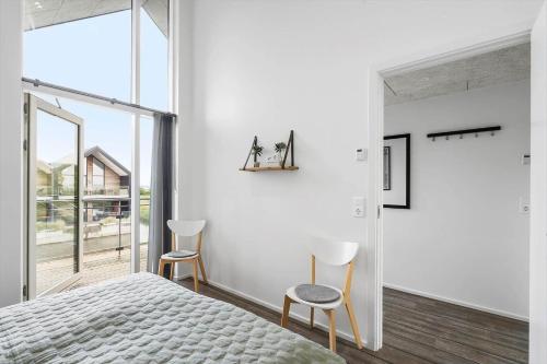 Un dormitorio con una cama y dos sillas. en 906-Hvide-Sande-Langsand-116-1-sal, en Hvide Sande