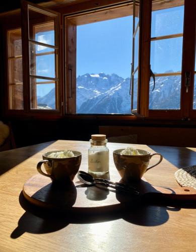 a table with two bowls on a table with a view at Heimelige Wohnung in einem Walliser Haus in Staldenried
