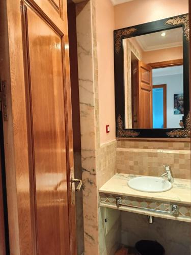 a bathroom with a sink and a mirror at Appartement standing piscine la palmeraie in Marrakech