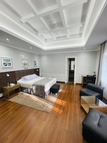a large bedroom with a bed and a couch at Hotel Casagrande in Arequipa