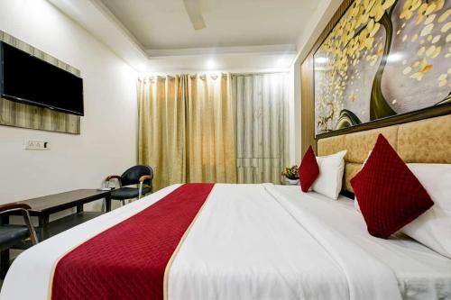 a hotel room with a large bed with red pillows at Hotel Lookout Stay in New Delhi