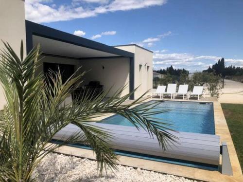 a villa with a swimming pool in front of a house at La Casa Fabrielo in Graveson