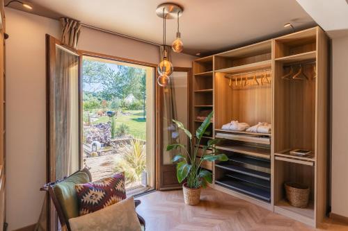 a dressing room with a large window and a sliding glass door at Maison du Bonheur avec Rivière & Spa, 4 chambres & 2 SDB in Tourville-en-Auge