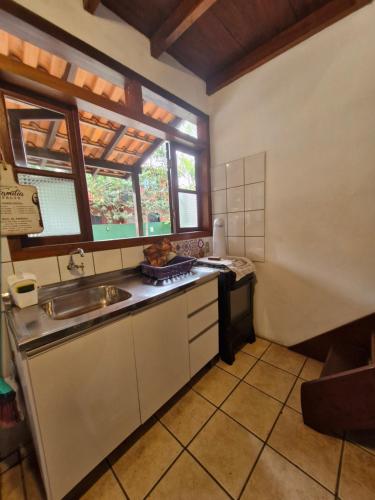 a small kitchen with a sink and a window at Pousada das Palmeiras in Garopaba