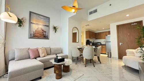 a living room with a couch and a table at Elegant 1BR Blossom Retreat - Masdar City in Abu Dhabi
