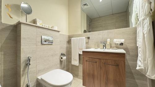 a bathroom with a white toilet and a sink at Elegant 1BR Blossom Retreat - Masdar City in Abu Dhabi