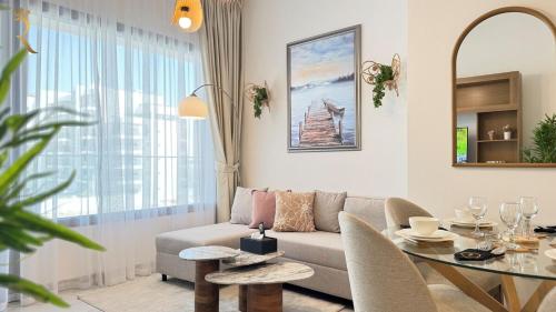 a living room with a couch and a table at Elegant 1BR Blossom Retreat - Masdar City in Abu Dhabi