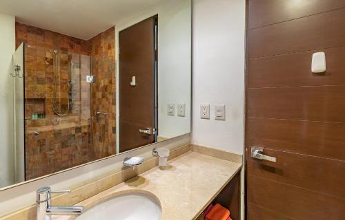 a bathroom with a sink and a shower at Papaya Plus in Playa del Carmen