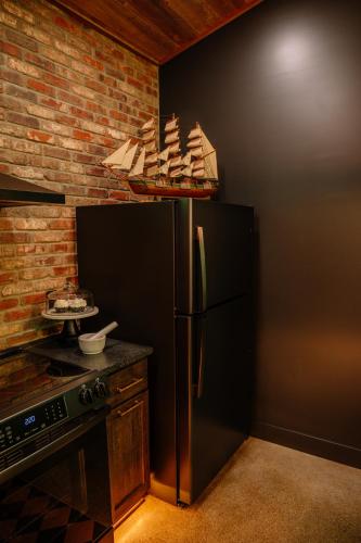 a kitchen with a black refrigerator and a brick wall at Whiskey Lounge in Loudonville
