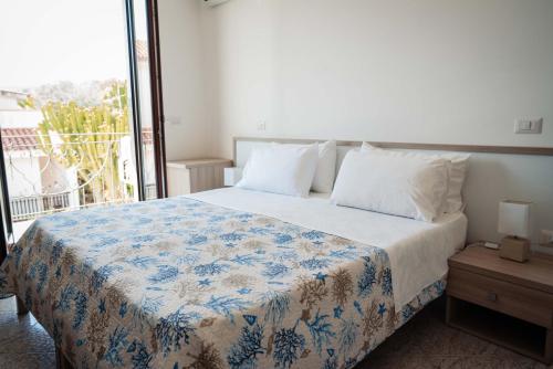 a bedroom with a bed with a blue and white blanket at Hotel Indaco in Marina di Casalvelino