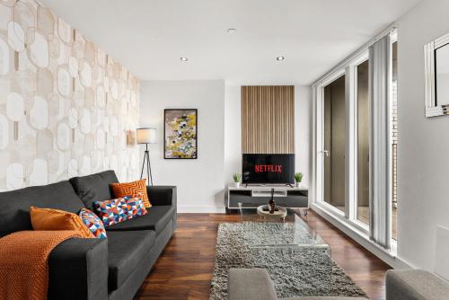 a living room with a couch and a tv at The Artist Abode in Central Manchester in Manchester