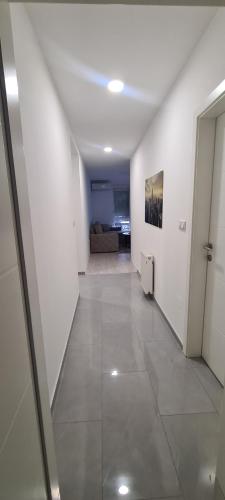 a white hallway with a couch in a room at A-Home apartman in Ši Selo