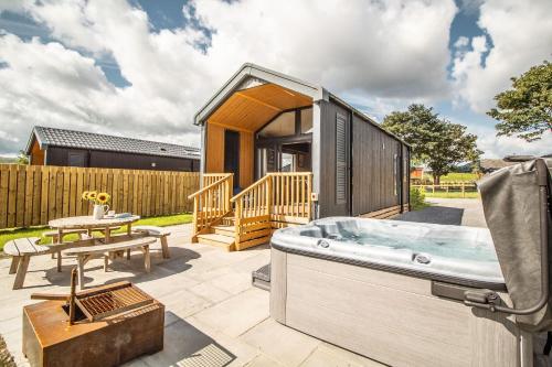 a tiny house with a hot tub on a patio at Daverneithon 2 in Rhayader