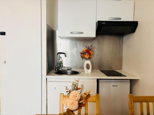 une cuisine avec un évier et un comptoir avec deux chaises dans l'établissement Apart 300m to Arc de Triomphe, à Paris