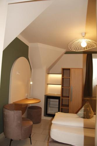 a bedroom with a bed and a chair and a fireplace at Gästehaus Centro in Konstanz in Konstanz