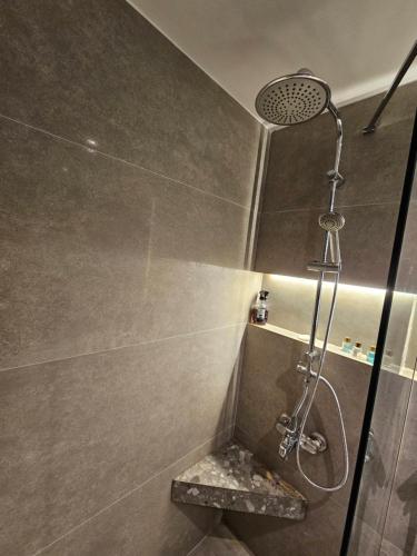 a shower with a shower head in a bathroom at حكايه للشقق الفندقية الفاخره Hikaye Suites Hotel in Bostancı