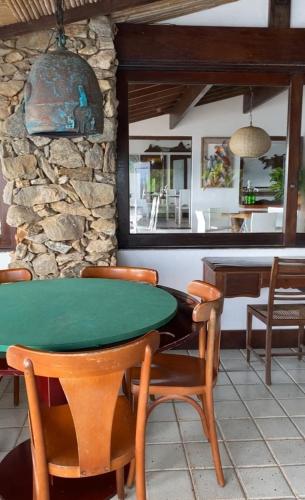a dining room with a green table and chairs at Pousada Casa do Bicho Preguiça in Angra dos Reis