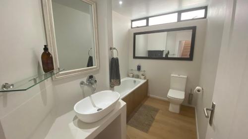 a white bathroom with a sink and a toilet at Witsand Holiday House in Witsand