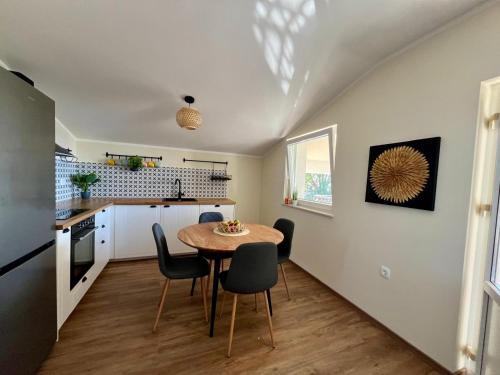 a kitchen and dining room with a table and chairs at Apartment More in Košljun