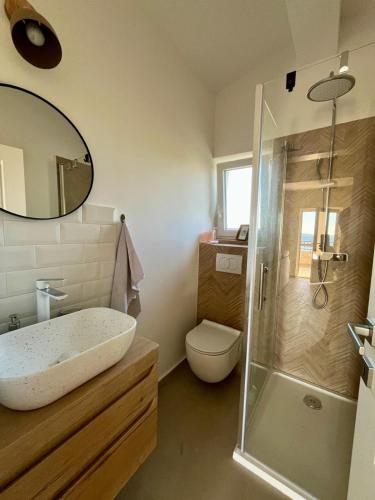 a bathroom with a sink and a toilet and a shower at Apartment More in Košljun