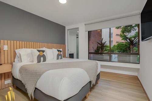 a bedroom with a large bed with two cats on it at Ankara 302 - Clean Comfy Loft Trendy in Provenza in El Poblado