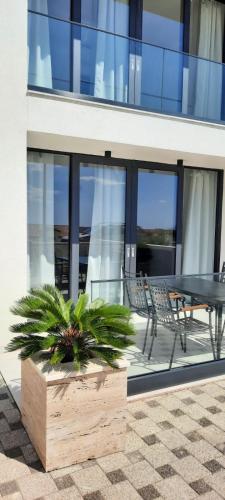 a glass building with a table and chairs in front of it at Villa royale with shared pool in Hvar