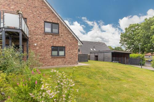 a brick house with a yard in front of it at Nordlicht in Breklum
