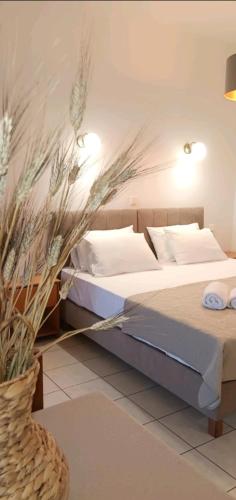 Un dormitorio con dos camas y un jarrón con flores. en ZOGRAFOS SPIROS Rooms, en Perdika