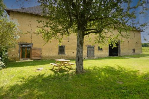 un tavolo da picnic accanto a un albero di fronte a un edificio di LA BERGERIE calm nature & authenticity a Paladru
