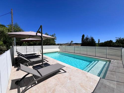 - une piscine avec une chaise et un parasol dans l'établissement Superbe maison en pierre avec piscine, à Saint-Avit