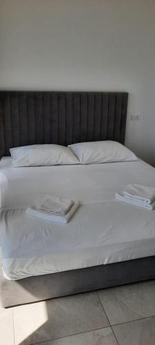 a bed with white sheets and pillows on it at Villa royale with shared pool in Hvar