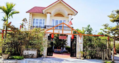 a house with a gate in front of it at Rose Homestay Cầu Ngói in Thôn Trường Giang