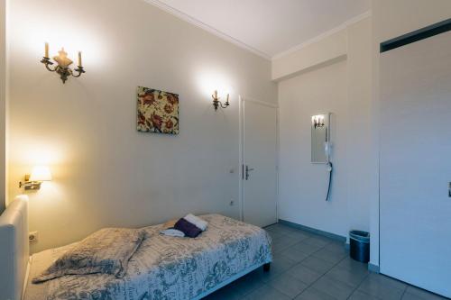a small bedroom with a bed and a bathroom at Hotel Villa Sevasti in Katerini