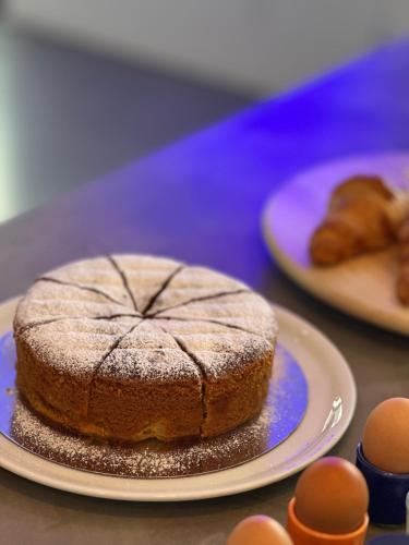 a cake on a plate on a table with eggs at Bica Vista in Lourinhã