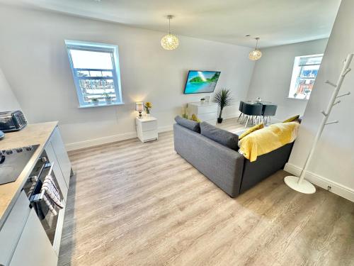 a living room with a couch and a table at Modern Flat Minutes Walk From Restaurants - Bars - Clubs - Beach in Bournemouth