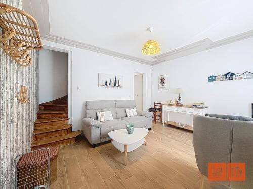 a living room with a couch and a table at Au Gré de la Mer in Wimille