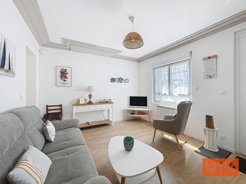 a living room with a couch and a table at Au Gré de la Mer in Wimille